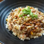 potret nasi goreng dengan hiasan bawang daun tersaji di atas piring