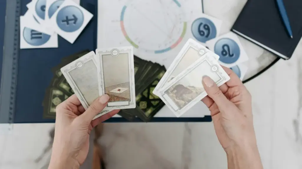 Tangan yang sedang memegang kartu tarot
