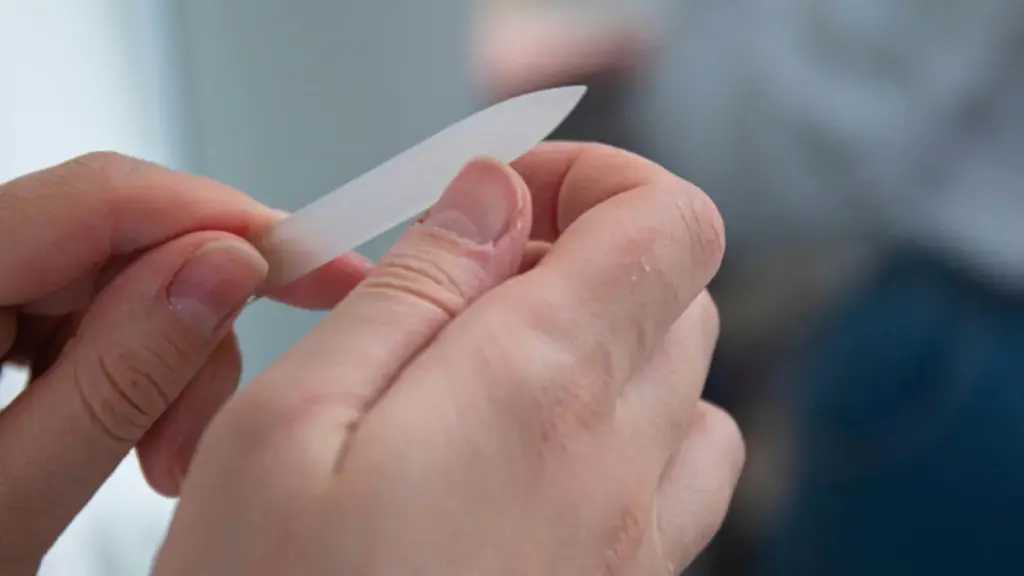 Potret seseorang sedang merawat kukunya menggunakan nail tools.