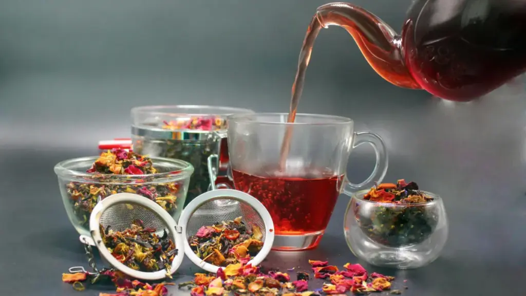 Potret sederet teh, saringan, dan teko yang sedang disiapkan untuk menyeduh teh.