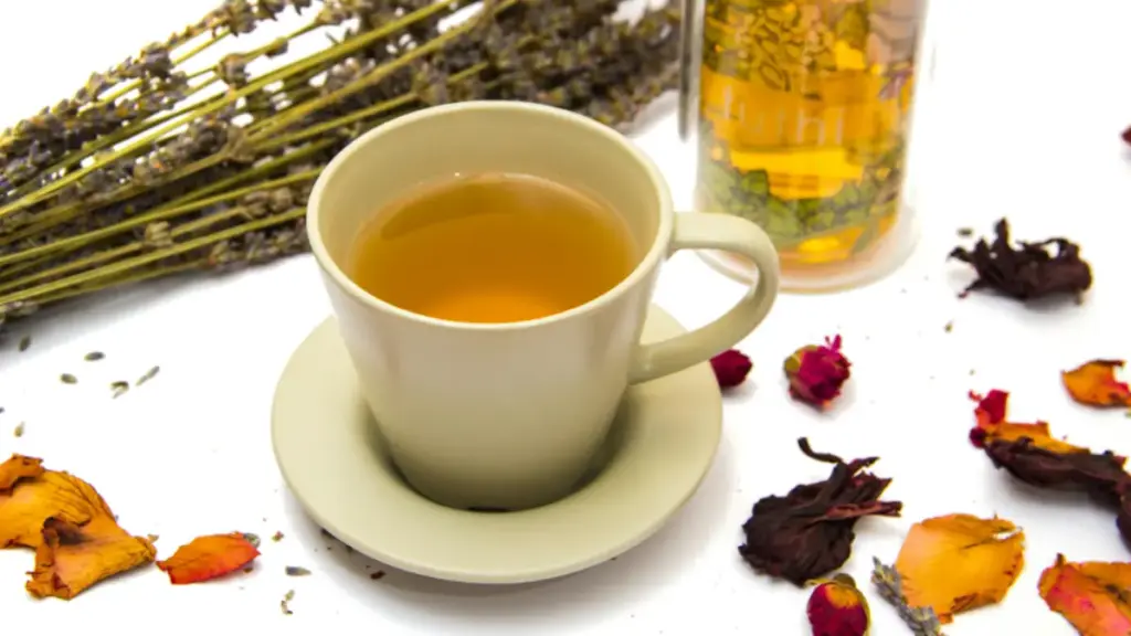 Potret secangkir teh disajikan di tengah dengan dekorasi dedaunan kering.