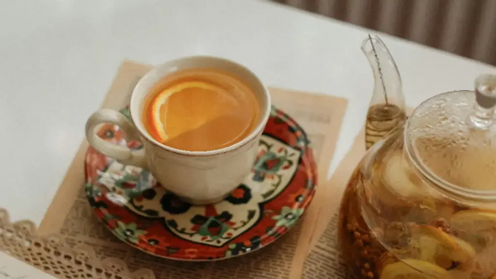 Secangkir jeruk hangat dengan teko gelas berisi minuman hangat