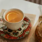 Secangkir jeruk hangat dengan teko gelas berisi minuman hangat