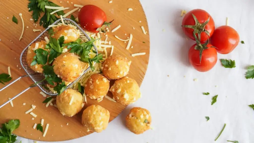 Potret sejumlah potato cheese ball tersaji diatas nampan kayu.