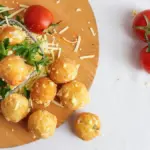 Potret sejumlah potato cheese ball tersaji diatas nampan kayu.