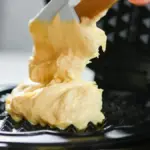 Potret sesorang sedang manuangkan adonan ke cetakan waffle menggunakan spatula