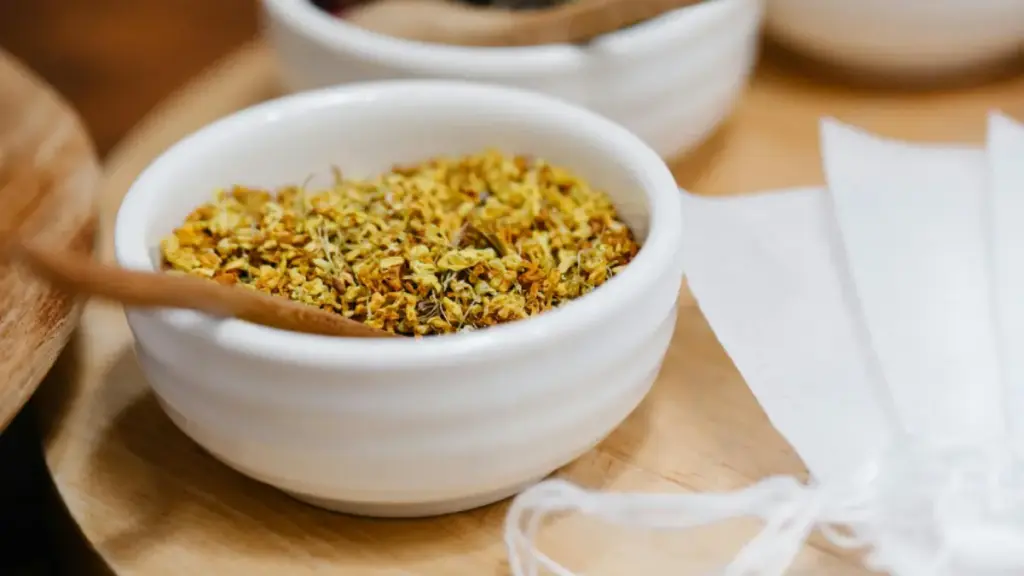 Potret semangkuk bunga osmanthus kering dengan sendok kayu