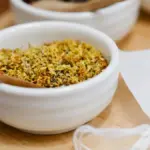 Potret semangkuk bunga osmanthus kering dengan sendok kayu