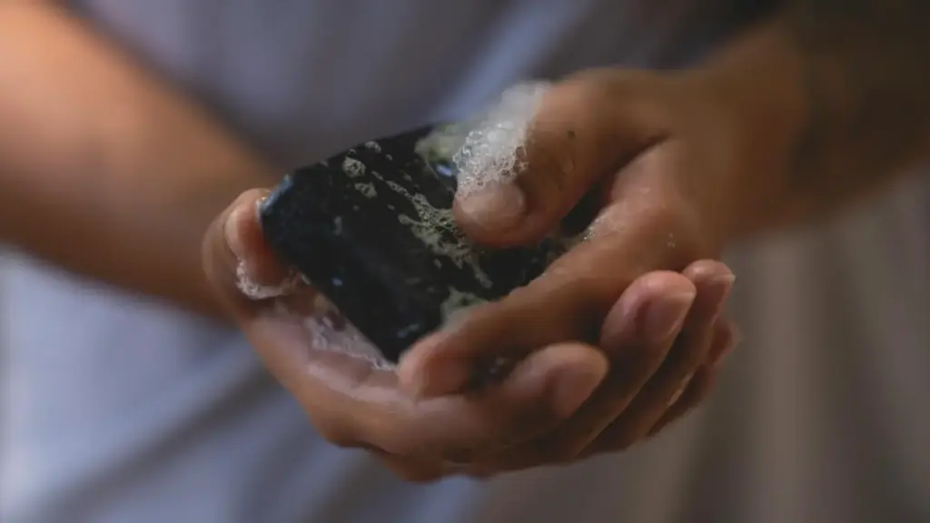 Potret seseorang sedang menggunakan sabun batang yang telah berbusa