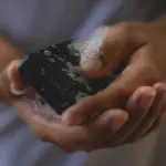 Potret seseorang sedang menggunakan sabun batang yang telah berbusa