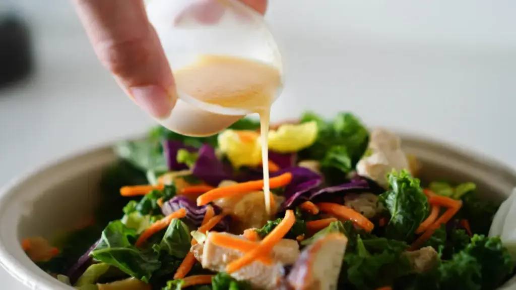 Potret seseorang menuangkan salad dressing
