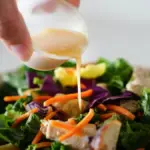 Potret seseorang menuangkan salad dressing