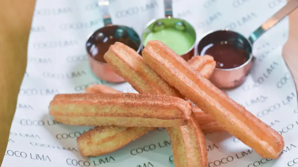 Potret sejumlah churros ditata saling bertumpukan dan didampingi dengan saus cokelat dan matcha.