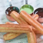 Potret sejumlah churros ditata saling bertumpukan dan didampingi dengan saus cokelat dan matcha.