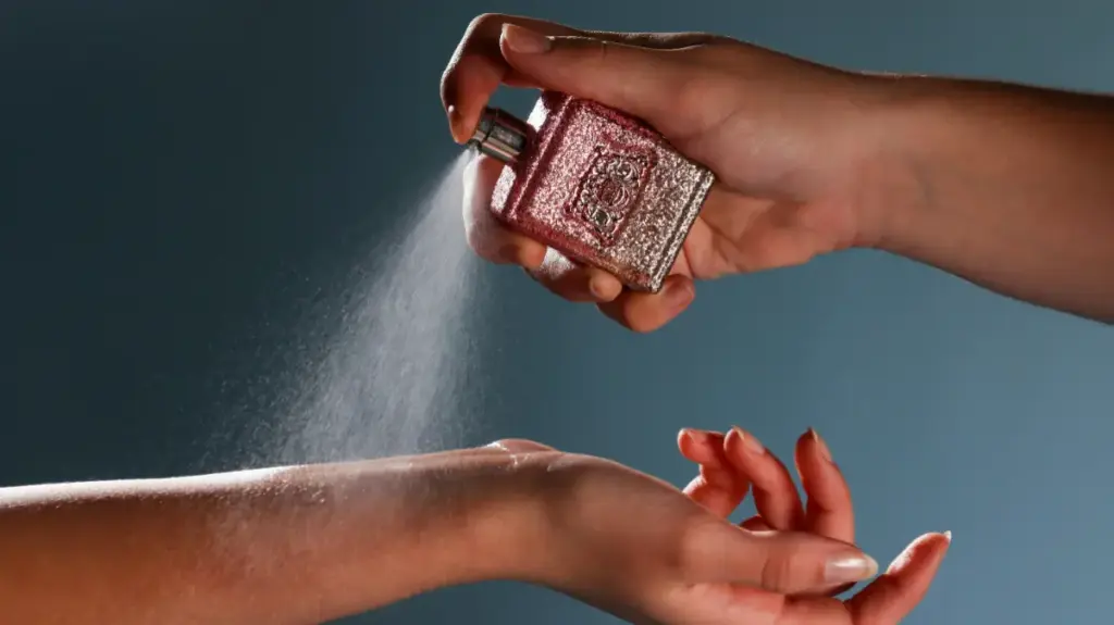 Potret seseorang sedang menyemprotkan parfum ke titik nadi