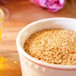 Semangkuk biji wijen diletakkan berdampingan dengan segelas minyak