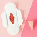 pembalut dengan noda darah dan cup untuk menahan aliran darah