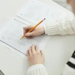 gambar berisi seorang anak yang sedang mengerjakan ujian