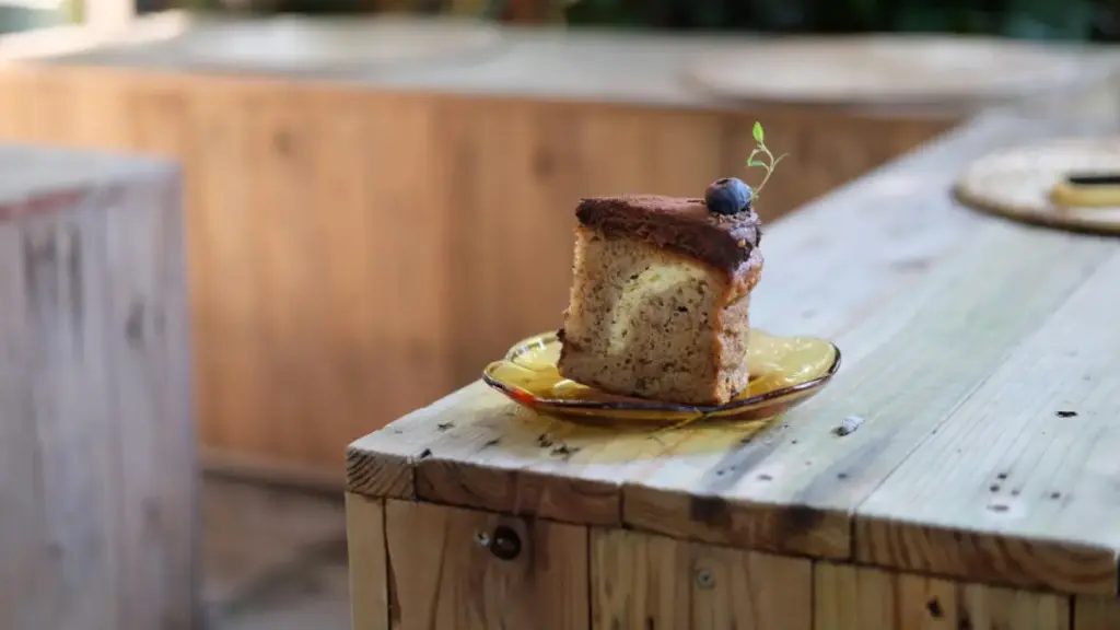 Potret sepotong banana cake dengan topping blueberry tersaji di atas piring