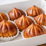 Potret butter tteok di dalam wadah dengan parchment paper