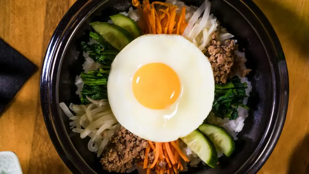 Potret semangkuk bibimbap berisi telur, daging, lobak, mentimun, wortel, dan nasi