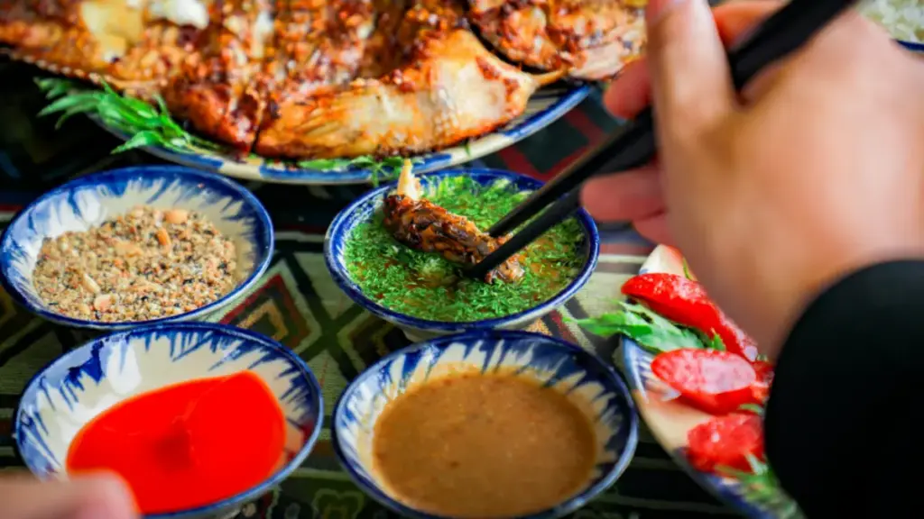 Potret seseorang mencelupkan makanan ke dalam campuran saus.