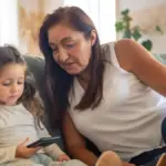 Potret seorang anak dan ibunya sedang menggunakan gadget