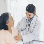 gambar berisi seorang dokter yang check kesehatan pasien
