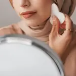 Potret perempuan berhijab sedang menggunakan gua sha