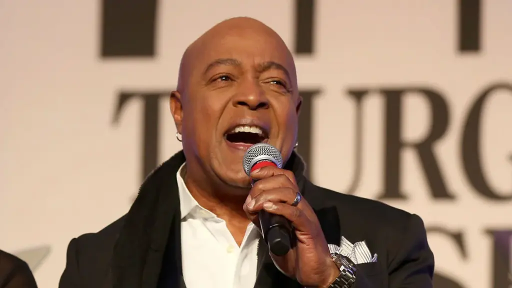 Potret peabo bryson sedang bernyanyi dan memegang mic